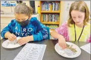  ?? (Submitted Photo) ?? Vanessa Martinez and Kyrie Pearson sift through the contents of the owl pellets.