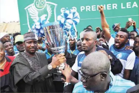  ??  ?? LMC boss, Shehu Dikko (left) presenting the Glo Premier league trophy to Enyimmba FC last Sunday in Lagos