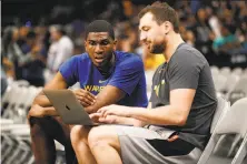  ?? Santiago Mejia / The Chronicle ?? The Warriors’ Kevon Looney talks with assistant coach Chris DeMarco before a preseason game last month.