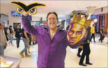  ?? Arash Markazi Los Angeles Times ?? GARY MARTIN ZELMAN, known by most fans as the “Lakers Sign Guy,” shows off two of his creations on opening night against the Clippers. Over the last 10 years, he has made signs for nearly every Lakers player.