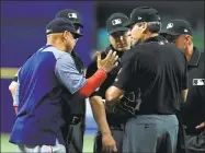  ?? Mike Ehrmann / Getty Images ?? Red Sox manager Alex Cora talks with the umpire crew about a defensive switch in the eighth inning against the Rays on Wednesday at Tropicana Field in St. Petersburg, Fla.