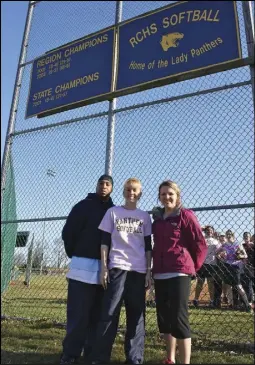  ?? Rappahanno­ck News staff photo/alex Sharp VIII ?? INSPIRING: Junior Panther softball head coach Heather Waddell, center, and volunteer assistant coaches Rachel Gall and Arathon Aylor pose before their “inspiratio­n board” at the softball field. “Hopefully these girls can add to that list of champions...
