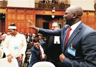  ?? AFP ?? Gambia’s Justice Minister Abubacarr Tambadou waves at a member of the Rohingya community prior to the ruling at The Hague in the lawsuit filed by Gambia against Myanmar.