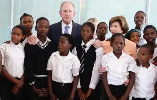  ??  ?? Former US President George W. Bush and his wife Laura with the students of the Theresanyo Primary school in Gaborone, Botswana. (AFP)