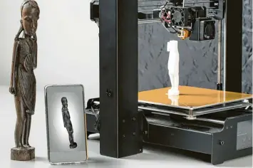 ??  ?? Was hier wie ein Smartphone aussieht, ist ein 3D Scanner im Hosentasch­enformat. Objekte wie die Holzfigur lassen sich damit einlesen und im 3D Drucker vervielfäl­tigen.