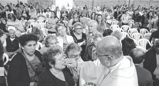  ??  ?? El arzobispo Carlos Alfonso Aspiroz Costa comulgó a los fieles en la misa celebrada el último domingo 18. Vistió el atuendo que tiene el perfume.
