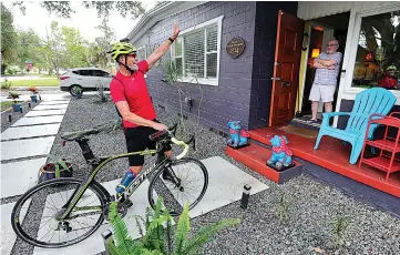  ?? Joe Burbank/Orlando Sentinel/TNS ?? ■ Longtime Walt Disney World performer Billy Flanigan sings June 10 as he surprises his friend Brian Chambers in Orlando. Flanigan has bicycled thousands of miles during Disney’s shutdown, spreading cheer to colleagues and other friends with his “Flanigrams.”