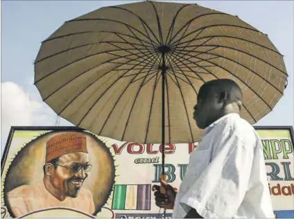  ??  ?? Same old, same old: A man walks past an electoral poster of President Muhammadu Buhari, who promised to tackle corruption when he was elected in 2015. Photo: Issouf Sanogo/AFP