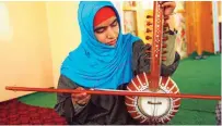  ??  ?? A Kashmiri muslim girl plays Sufi music.