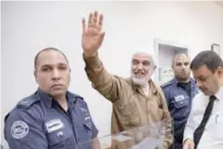  ??  ?? TEL AVIV: Arab-Israeli Sheikh Raed Salah, leader of the radical northern branch of the Islamic Movement in Israel, waves as he arrives at the Israeli Rishon Lezion Justice court yesterday. — AFP