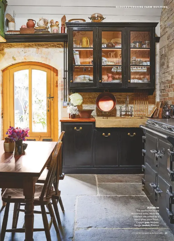  ??  ?? Kitchen
The worksurfac­es are reclaimed Iroko, while the cabinets are united by a black gloss paint finish. Copper pan, Nisbets. Range cooker, Everhot