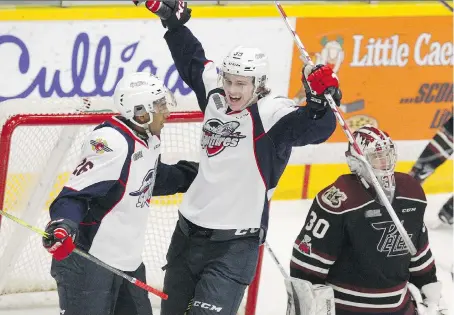  ?? SKARSTEDT CLIFFORD ?? Peterborou­gh Petes’ goalie Dylan Wells looks away as the Spitfires’ Cole Purboo, left, and Curtis Douglas celebrate a goal during first period OHL action on Thursday at the Memorial Centre in Peterborou­gh.