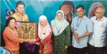  ?? PIC BY HARUN YAHYA ?? PKR president and Deputy Prime Minister Datuk Seri Dr Wan Azizah Wan Ismail receiving a souvenir after a meet-the-people session at the Rumah Panjang Rengayan Anak Ngumbang in Nanga Ruyak, Julau, yesterday. With her is Julau member of parliament Larry Sng Wei Shien (second from left).