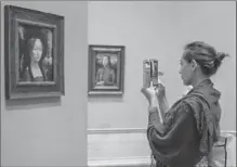  ?? JOHN KELLY, THE WASHINGTON POST ?? Shannon O’Connell of Boston takes a photo of Leonardo da Vinci’s portrait of Ginevra de’ Benci at Washington’s National Gallery of Art.