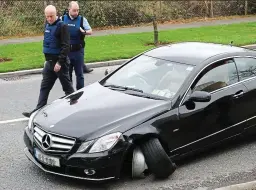  ??  ?? Terrifying: The sub-machine gun Rafferty was wielding. Right, gardaí inspect one of the cars damaged during the rampage