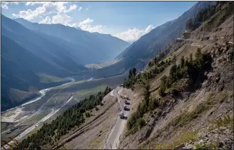  ?? ?? Vehicles move through the Zojila Pass on Monday northeast of Srinagar, Indian-controlled Kashmir.