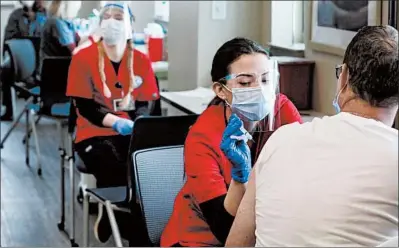  ?? ANTONIO PEREZ/ CHICAGO TRIBUNE PHOTOS ?? Nursing student Micaela Soderman, second from right, from the Lewis University College of Nursing, volunteers administer­ing the Moderna COVID-19 vaccine to people at Will County Community Health in Joliet on Feb. 8.