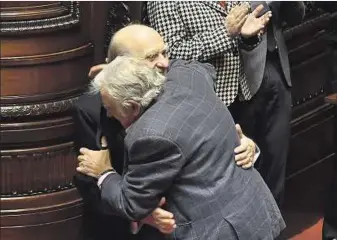  ??  ?? JUNTOS. Apenas terminó su discurso, Mujica levantó las manos y se abrazó con el colorado Sanguinett­i.