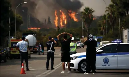  ?? Photograph: Yannis Kolesidis/EPA ?? Police and residents in north Athens watch anxiously as a forest wildfire rages towards their suburb.