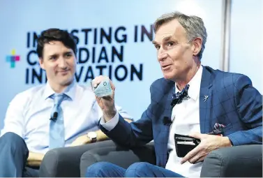  ?? JUSTIN TANG / THE CANADIAN PRESS ?? Bill Nye shows off a Canadian $5 bill, which features an astronaut and the Canadarm, as Prime Minister Justin Trudeau looks on during an armchair discussion highlighti­ng Canadian innovation at the University of Ottawa on Tuesday.