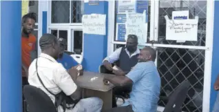  ?? (Photo: Gregory Bennett) ?? National Water Commission workers playing a game of dominoes during the islandwide strike last Tuesday.