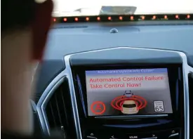  ??  ?? Virginia Tech Center for Technology Developmen­t Program Administra­tion Specialist Greg Brown seen behind the wheel of a driverless car during a test ride showing the alert system handing over automation to the driver while traveling street in...