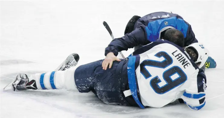  ?? — THE ASSOCIATED PRESS ?? Jets forward Patrik Laine is helped by athletic therapist Rob Milette after being levelled by a hit from the Sabres’ Jake McCabe Saturday in Buffalo.
