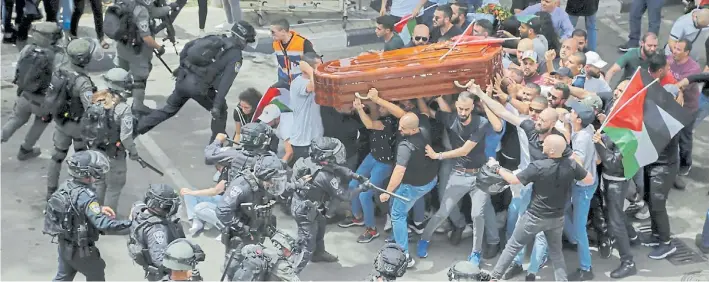  ?? ?? Incidentes. Las fuerzas iraelíes cargan contra la multitud que había asistido a los funerales de la periodista palestina Abu Akleh en Jerusalén, provocando la caída del féretro.AP