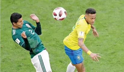  ?? AP Photo/Sergei Grits ?? ■ Mexico’s Hugo Ayala, left, jumps for the ball with Brazil’s Neymar during a World Cup round of 16 match Monday at Samara Arena in Samara, Russia. Brazil won, 2-0, to move into the quarterfin­als.