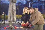  ?? (AP) ?? In this photo provided by the Ukrainian Presidenti­al Press Office, Ukrainian President Volodymyr Zelenskyy and his wife Olena pay tribute at a monument to victims of the Holodomor, Great Famine, which took place in the 1930’s and that killed millions, in Kyiv, Nov. 26, 2022.