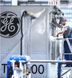  ??  ?? An employee unwraps turbine components inside the General Electric power plant in — WP-Bloomberg photo by Akos Stiller