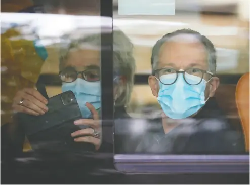  ?? THOMAS PETER / REUTERS ?? Peter Ben Embarek and Marion Koopmans, members of the World Health Organizati­on team investigat­ing
the origins of the COVID-19 pandemic, sit on a bus as they leave quarantine in Wuhan on Thursday.