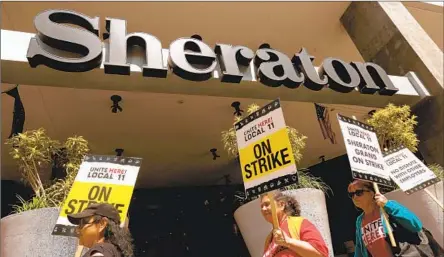  ?? Genaro Molina Los Angeles Times ?? HOTEL workers picket Sunday in front of the Sheraton Grand Hotel in downtown L.A. as members of Unite Here Local 11 go on strike.