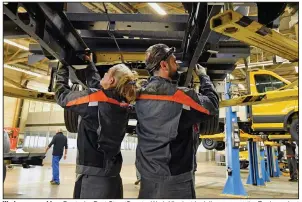  ?? (AP) ?? Workers assemble a Deutsche Post StreetScoo­ter Work XL electric delivery van at the Ford car plant in Cologne, Germany, in 2018. Ford says it will spend $1 billion to modernize its Cologne plant, converting it into a European electric vehicle factory.