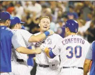  ?? Frank Franklin II / Associated Press ?? The Mets’ Brandon Nimmo celebrates with teammates Kevin Plawecki and Michael Conforto after hitting a walk-off three-run home run during the 10th inning against the Phillies on Wednesday.