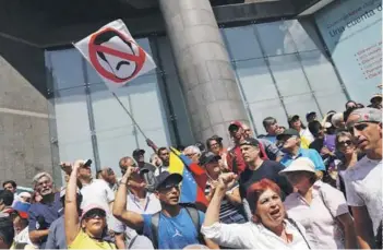  ??  ?? Opositores al régimen de Maduro se manifiesta­n fuera del Parlamento, el viernes.