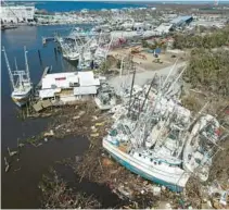  ?? REBECCA BLACKWELL/AP ?? Grounded shrimp boats lie bunched together amid debris on San Carlos Island in Fort Myers Beach on Oct. 7. It has now been almost two months since the hurricane hit Florida, and recovery efforts continue with the crucial help of volunteers.