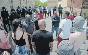  ?? JIM MONE THE ASSOCIATED PRESS ?? Protesters face off with police outside of a police station on Thursday in Minneapoli­s after a night of rioting, as protests continue over the arrest of George Floyd, who died in custody on Monday.