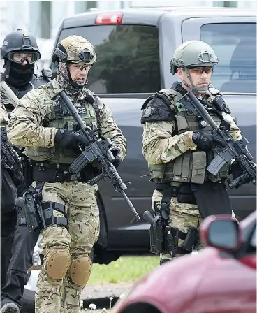  ?? ANDREW VAUGHAN / THE CANADIAN PRESS FILES ?? Emergency response officers check a Moncton residence in June 2014 searching for a suspect who shot and killed three RCMP officers.