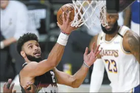  ?? AP photo ?? The Nuggets’ Jamal Murray goes up for a shot as the Lakers’ LeBron James looks on during Denver’s 114-106 victory over Los Angeles in Game 3 of the Western Conference finals Tuesday.