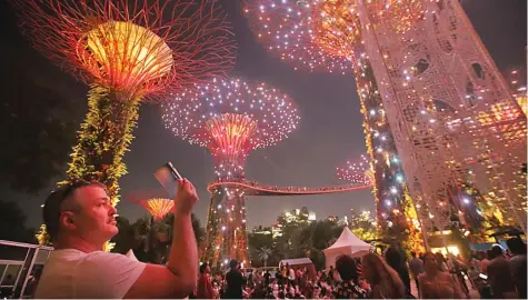  ?? HANUNG HAMBARA/JAWA POS ?? GEMERLAP: Pengunjung menyaksika­n pertunjuka­n lampu dan musik di Gardens by the Bay, Singapura, menjelang pergantian tahun tadi malam.