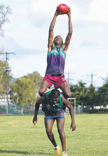  ?? Picture: ANNA ROGERS ?? AIMING HIGH: Cairns Saints youngster Fitzroy Greenwool takes a mark on fellow AFL Cape York House student Phillip Toby.