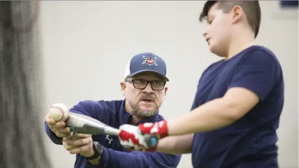  ?? STAN BEHAL ?? Gregg Zaun instructs Jonathan Donia, 12, at his hitting camp in Kleinburg, Ont., Thursday. The former Blue Jays catcher has also taken up boxing since being fired by Sportsnet.