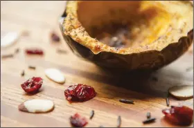  ?? Food styling/KELLY BRANT Arkansas Democrat-Gazette/JEFF GAMMONS ?? Acorn Squash is delicious sprinkled with brown sugar and baked before getting stuffed with wild rice, almonds and cranberrie­s.