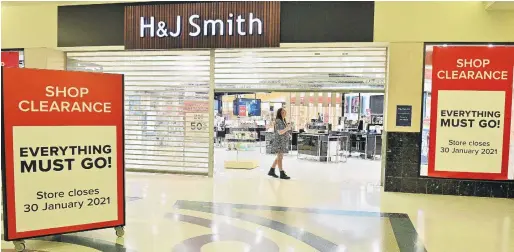  ?? PHOTOS: LINDA ROBERTSON ?? The race is run . . . H&J Smith retail assistant Sophie Smith closes the door on the Dunedin store for the final time on Saturday.