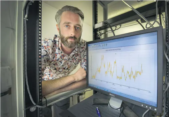  ?? ARLEN REDEKOP/PNG ?? Kyle Howe poses with a monitor showing measured air particles at an air-quality testing station in Burnaby on Tuesday.