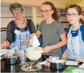  ??  ?? In der Schulküche zeigten Lea Sofie und Leonie (mit Schürze), beide aus der Klasse 7d, wie Windbeutel hergestell­t werden.