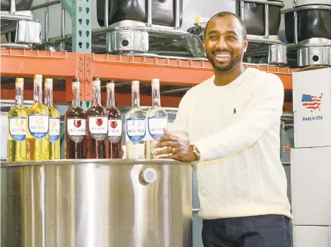  ?? MONICA CABRERA/THE MORNING CALL ?? Russell Fletcher II, owner of Mishka Premium Vodka, shows off his wares at the distillery on North Gilmore Street in Allentown. Fletcher, who says he owns the oldest master distiller’s license by a Black person in the U.S., is looking for a bigger location as his business grows.