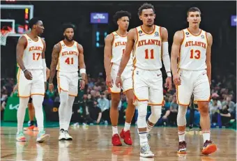  ?? AP PHOTO/MICHAEL DWYER ?? From left, Atlanta’s Onyeka Okongwu, Saddiq Bey, Jalen Johnson, Trae Young and Bogdan Bogdanovic walk to the visitors’ bench at the end of the third quarter of Saturday’s game against the Boston Celtics. The Hawks lost 112-99 as the NBA’s Eastern Conference playoffs tipped off.