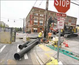  ?? Ted S. Warren Associated Press ?? TACOMA, WASH., is altering some of its planned water main replacemen­ts because of rising costs. Above, workers prepare to install water pipes downtown.